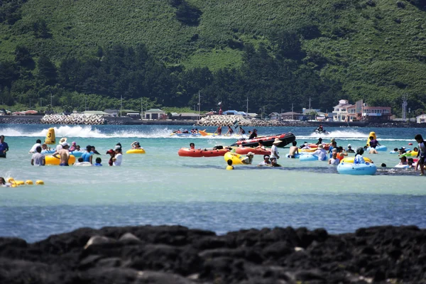 लोग दक्षिण कोरिया में सुंदर जेजू द्वीप पर आराम और स्नान करते हैं Hyeopjae समुद्र तट — स्टॉक फ़ोटो, इमेज