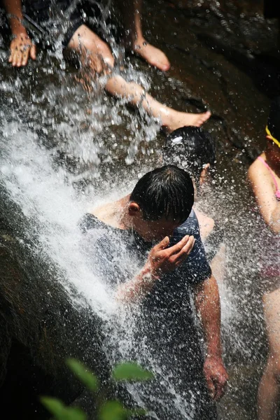 人们在相提并论瀑布里游泳。 — 图库照片