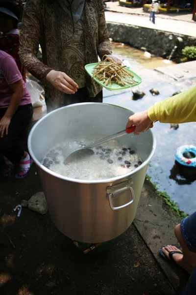 La gente cocina comida en una tina grande — Foto de Stock