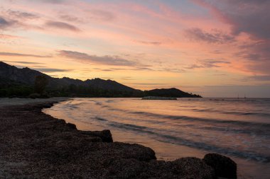 Gün batımında Saint Florent Korsika sahilinde, arkasında dağlar vardı. tatil yeri ..