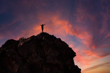 Günbatımında bir dağın tepesinde duran adam seyahat ve macera tatili Korsika, başarı kavramı.