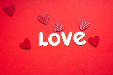 the word love on red background with small red hearts for valentines day