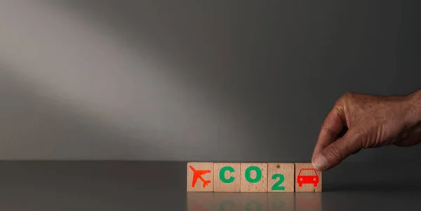 concept of carbon reduction and transport .wooden blocks with car and plane on a grey background
