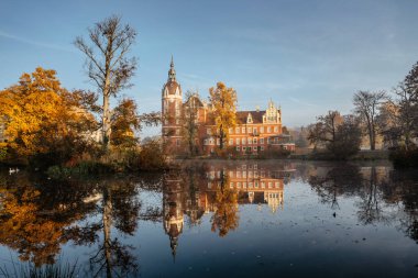 Prens Pueckler Parkı ve kalesi suya, Kötü Muskau Alman Polonya sınırına yansıdı. Manzaralı sonbahar manzarasının muhteşem panoramik manzarası. UNESCO Sitesi. Neisse Nehri 'ndeki başyapıt. Turist kültür merkezi.