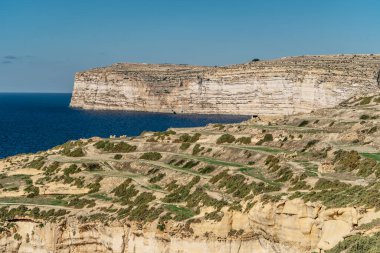 Gozo adası ve Akdeniz 'in Rocky kireçtaşı kıyı şeridi turkuvaz mavisi su ve mağaraları. Yeşil teraslı tarlalar, tepeler. Muhteşem manzaralı popüler yürüyen uçurum Xindi rotası. Aktif bir gün..