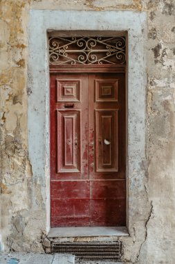 Malta, şaşırtıcı derecede eşsiz kapılara ev sahipliği yapıyor. Vallet 'te geleneksel renkli Malta kapısı. Malta' dan itibaren kapı kapı dolaşacağız. Kırmızı, eski, ahşap kapı ve taş cephe.