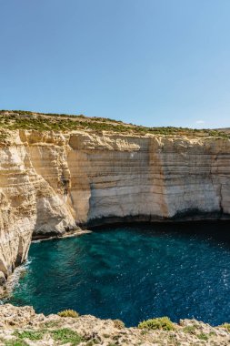 Gozo adası ve Akdeniz 'in kayalık kireçtaşı kıyı şeridi turkuvaz mavisi su ve mağaralarla. Malta kıyıları boyunca yürümek için harika bir yer.