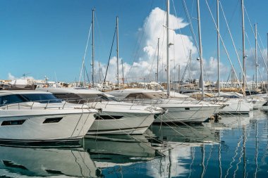 Limandaki lüks tekne ve yatlar. Güneşli bir yaz günü. Tatil lisesi seyahat konsepti. Akdeniz 'de tekne gezisi. Rıhtımda su yansıtmalı pahalı yelkenli yatları manzarası..