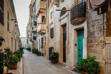 Valletta 'da geleneksel renkli Malta kapıları. Malta 'dan gelen evlerin ön kapıları. Mavi yeşil kapılar ve ahşap balkon. Malta 'nın klasik apartmanları. Popüler seyahat yerleri. Eve Giriş