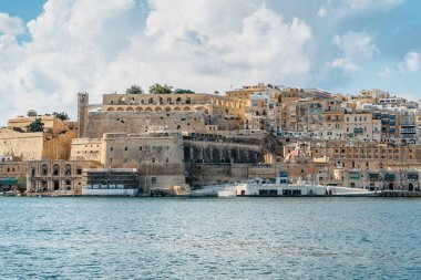 Valletta, Malta 'nın panoramik manzarası. Birgu Vittoriosa limanından şehir silueti. Huzurlu şehir manzarası, güneşli yaz günü. Rıhtım evleri ve Yukarı Barrakka Bahçeleri..