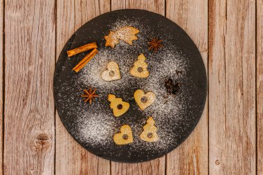 Koyu tabakta ev yapımı lezzetli kurabiyeler. Noel kurabiyesi deseni. Kış tatili tatlı süsü alanı. Yılbaşı baharatları.