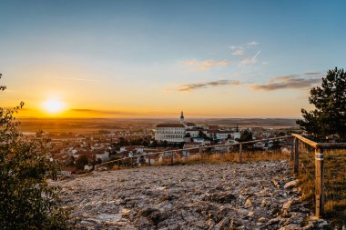 Mikulov 'un gün batımında kayanın üzerinde güzel bir Barok kalesi, güney Moravya, Çek Cumhuriyeti Skyline. Palava şarap bölgesinde Çek Şatosu. Üzüm bağları arasında resim gibi bir kasaba.