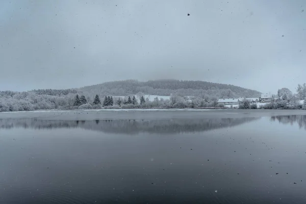 Cloudy Snowy Winter Day Lake Small Village Background Trees Reflected — Fotografia de Stock