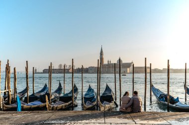 Venedik, İtalya 'da sevgili olan bir çift. Arka planda San Giorgio Maggiore kilisesi, ünlü kanal ve geleneksel gondollar. Venedik şehir yaşam tarzı, seyahat manzarası. Venezia' nın mimarisi ve simgesi.