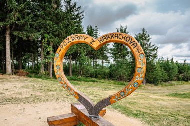 Harrachov,Czech Republic-August 13,2022. Photo frame with wooden heart and sign Hello from Harrachov.Certova hora,Krkonose mountains. Popular tourist attraction.Outdoor activities,romantic scenery.