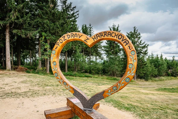 Harrachov,Czech Republic-August 13,2022. Photo frame with wooden heart and sign Hello from Harrachov.Certova hora,Krkonose mountains. Popular tourist attraction.Outdoor activities,romantic scenery.
