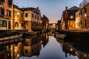 Alacakaranlıkta su kanalı, Venedik, İtalya. Tipik tekne ulaşımı, Venedik şehir manzarası. Su taşımacılığı. Popüler turizm merkezi. Romantik sakin atmosfer..