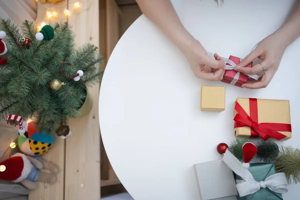 フラットレイの女性の手はクリスマスツリーと新年のギフトボックスを飾る — ストック写真