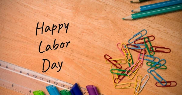 Ahşap masadaki çoklu okul ekipmanından mutlu işçi günü mesajları. İşçi bayramı konsepti