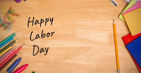 Ahşap masadaki çoklu okul ekipmanından mutlu işçi günü mesajları. İşçi bayramı konsepti