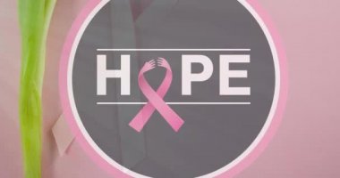 Umut ve pembe kurdelenin pembe arka planda lale ile daire çizmesi. Göğüs kanseri pozitif farkındalık kampanyası konsepti dijital olarak üretildi.