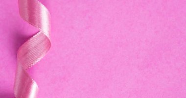 Pembe arka planda sarmal pembe kurdelenin animasyonu. Göğüs kanseri pozitif farkındalık kampanyası konsepti dijital olarak üretildi.