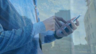 Şehir manzarası üzerinde akıllı telefon kullanan bir adamın animasyonu. küresel bağlantılar, teknoloji ve dijital arayüz konsepti dijital olarak oluşturulmuş video.