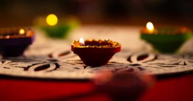 Kırmızı ve beyaz yüzeyde daireler çizerek parlayan diwali mumlarının videosu. diwali, ışık festivali, yeni yıl, gelenek ve kutlama konsepti.