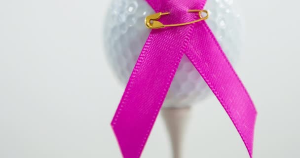 Animering Rosa Band Säkerhetsnål Och Golfboll Vit Bakgrund Bröstcancer Positiv — Stockvideo
