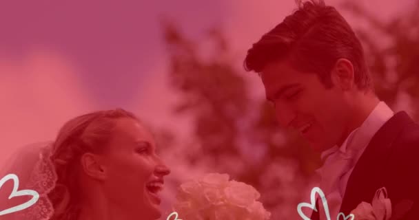 結婚式の服を着てキスをする白人夫婦の上に白い心のアニメーション 婚約恋愛愛の概念をデジタルで生成したビデオ — ストック動画