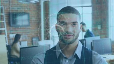 Gülümseyen melez adamın ofisinde dönen ağ ve veri işleme animasyonu. küresel iş iletişimi ve veri ağı konsepti dijital olarak oluşturulmuş video.
