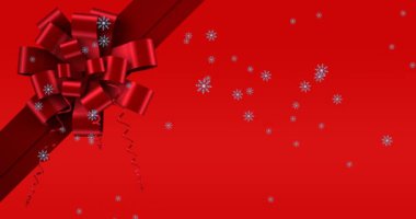 Kırmızı arka planda kurdelenin üzerine düşen kar animasyonu. Noel, gelenek ve kutlama konsepti dijital olarak oluşturuldu.