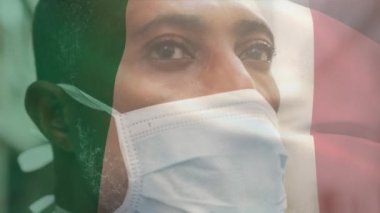 Covid 19 salgını sırasında maske takan adamın üzerinde sallanan İtalyan bayrağının animasyonu. küresel covid 19 salgın konsepti dijital olarak oluşturulmuş video.