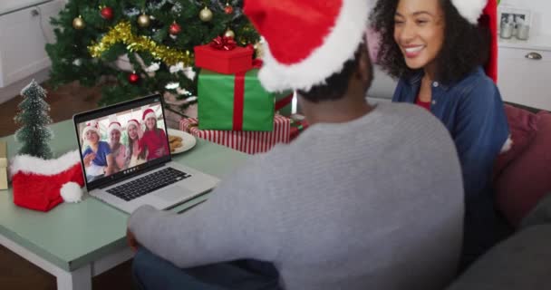 クリスマスの間 自宅のノートパソコンでサンタの帽子をかぶっているアフリカ系アメリカ人のカップル クリスマスの時期に流行した19種のパンデミックの間の社会的距離は — ストック動画