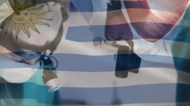 Ameliyathanede cerrahların üzerinde sallanan uruguay bayrağının animasyonu. küresel tıp, covid 19 pandemik konsept sırasında sağlık hizmetleri dijital olarak üretilen video.