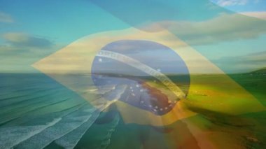 Plaj ve deniz dalgalarının havadan görüntüsüne karşı Brezilya bayrağı sallamanın dijital bileşimi. Ulusal turizm ve seyahat kavramı