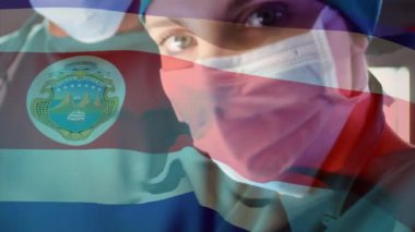 Kosta Rika bayrağının ameliyathanede kadın cerrah üzerinde dalgalanması. küresel tıp, covid 19 pandemik konsept sırasında sağlık hizmetleri dijital olarak üretilen video.