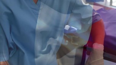 Ameliyathanede cerrahların üzerinde sallanan Fransa bayrağının animasyonu. küresel tıp, covid 19 pandemik konsept sırasında sağlık hizmetleri dijital olarak üretilen video.