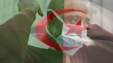 Cezayir bayrağının animasyonu. Covid 19 salgını sırasında yüz maskesi takan adamın üzerinde sallanıyor. küresel covid 19 salgın konsepti dijital olarak oluşturulmuş video.
