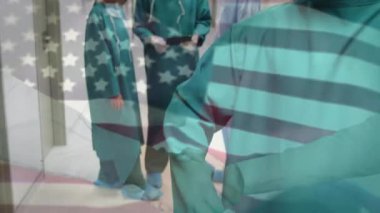 Ameliyathanede cerrahların üzerinde sallanan ABD bayrağının animasyonu. küresel tıp, covid 19 pandemik konsept sırasında sağlık hizmetleri dijital olarak üretilen video.