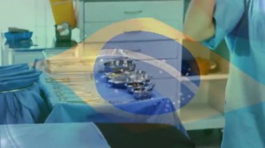 Ameliyathanede cerrahların üzerinde sallanan Brezilya bayrağının animasyonu. küresel tıp, covid 19 pandemik konsept sırasında sağlık hizmetleri dijital olarak üretilen video.
