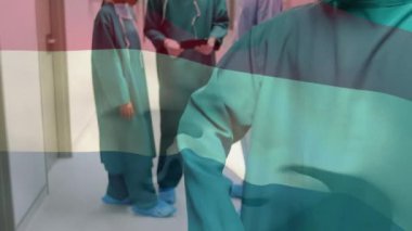 Ameliyathanede cerrahların üzerinde sallanan Hollanda bayrağının animasyonu. küresel tıp, covid 19 pandemik konsept sırasında sağlık hizmetleri dijital olarak üretilen video.
