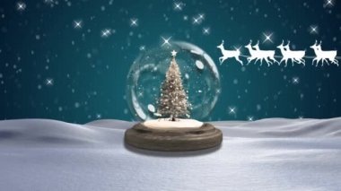 Kar, kar küresindeki bir Noel ağacının üzerine düşüyor. Kış manzarası mavi arka planda. Noel şenliği ve kutlama konsepti