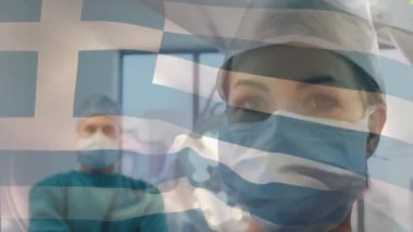 Ameliyathanede cerrahların üzerinde sallanan Yunan bayrağının animasyonu. küresel tıp, covid 19 pandemik konsept sırasında sağlık hizmetleri dijital olarak üretilen video.