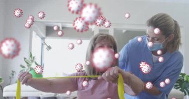 Kadın sağlık çalışanlarına karşı kombine 19 hücre direniş bandıyla egzersiz yapan yaşlı kadınlara yardım ediyor. Coronavirus covid-19 salgın konsepti
