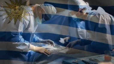 Ameliyathanede cerrahların üzerinde sallanan uruguay bayrağının animasyonu. küresel tıp, covid 19 pandemik konsept sırasında sağlık hizmetleri dijital olarak üretilen video.