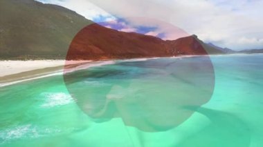 Denizde dalgaların havadan görüntüsüne karşı japan bayrağı sallamanın dijital bileşimi. Ulusal turizm ve seyahat kavramı