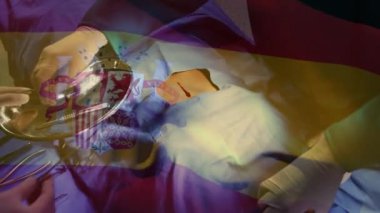 Ameliyathanede cerrahların üzerinde İspanya bayrağı animajı. küresel tıp, covid 19 pandemik konsept sırasında sağlık hizmetleri dijital olarak üretilen video.