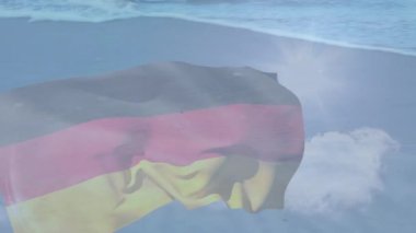 Sahile ve deniz dalgalarına karşı Alman bayrağı sallamanın dijital bileşimi. Ulusal turizm ve seyahat kavramı