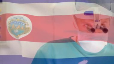 Kosta Rika bayrağının ameliyathanede cerrahların üzerinde dalgalanması. küresel tıp, covid 19 pandemik konsept sırasında sağlık hizmetleri dijital olarak üretilen video.
